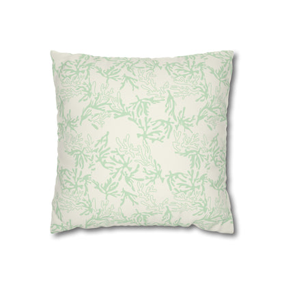 A square throw pillow with a light sage green coral pattern on an off-white background