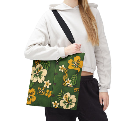 A woman wearing a white cropped hoodie and black sweatpants carries a green tote bag with a yellow and cream hibiscus floral print and a black shoulder strap against a plain white background.