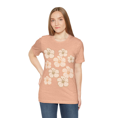 Woman wearing Hibiscus All Over Graphic Tee featuring scattered tropical hibiscus flowers on a soft unisex tee inspired by island life in Hawaii.