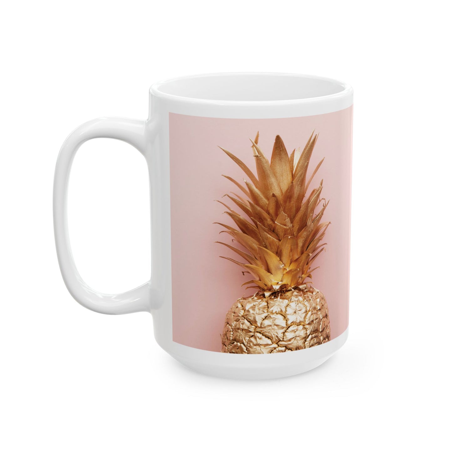 A white ceramic mug featuring a printed graphic of a golden pineapple on a dusty pink background.