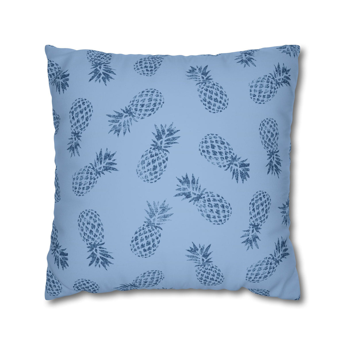 A square throw pillow featuring a repeating dark blue pineapple pattern on a light blue background, shown against a plain white studio backdrop.