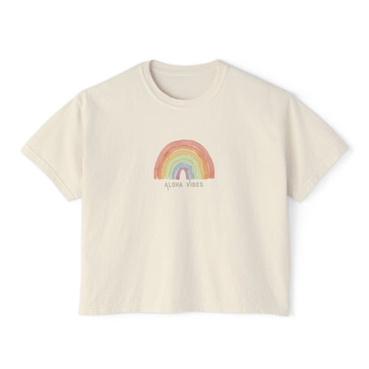 An off-white short-sleeve crop top t-shirt featuring a pastel rainbow graphic on the chest with the text 'ALOHA VIBES' underneath, displayed on a clean white background.