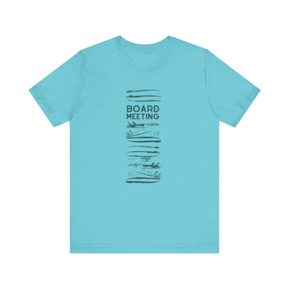 A light blue short-sleeve crewneck t-shirt with a vertical graphic on the front featuring the words 'BOARD MEETING' in dark gray text surrounded by surfboards, displayed on a solid white background.