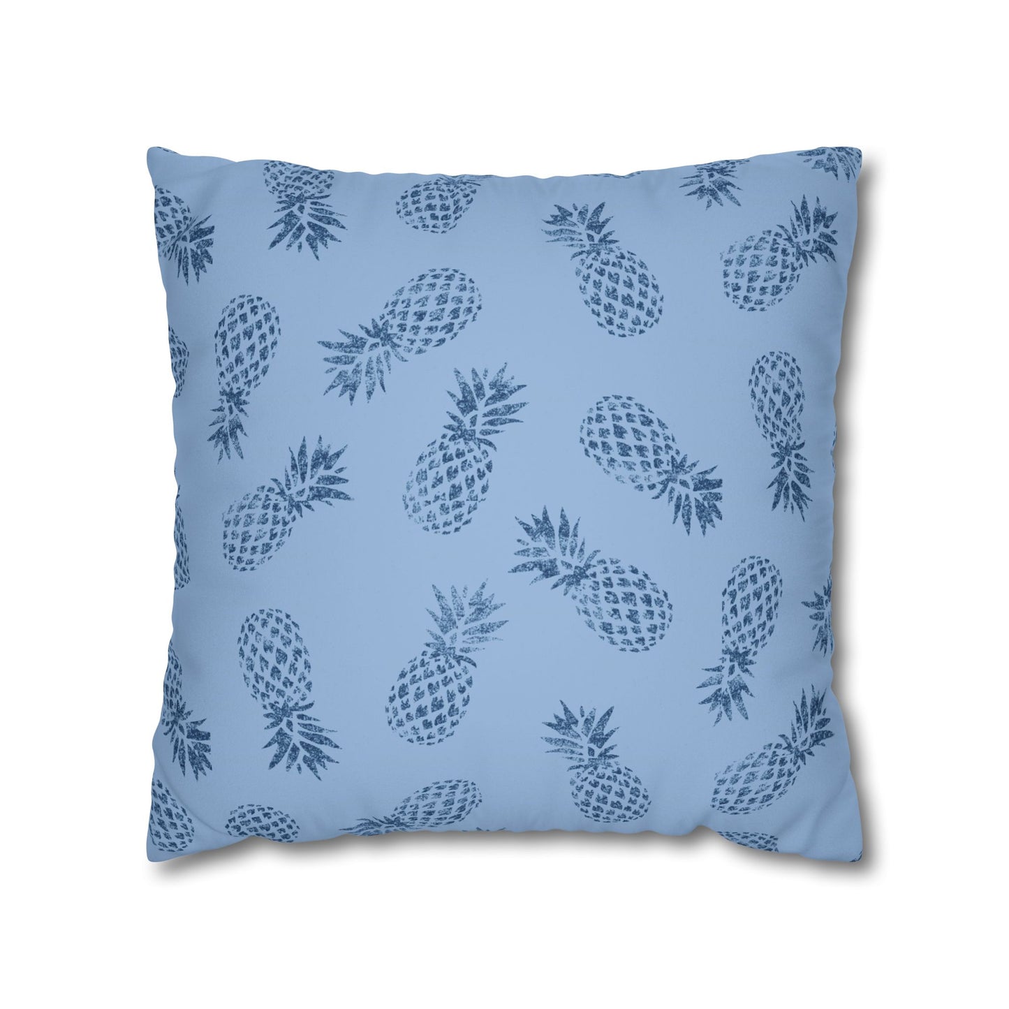 A square throw pillow featuring a repeating dark blue pineapple pattern on a light blue background, shown against a plain white studio backdrop.