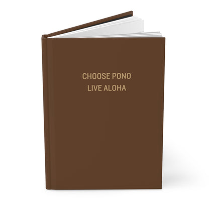 A hardcover notebook or journal with a solid brown cover, featuring the text 'CHOOSE PONO LIVE ALOHA' in gold lettering on the front cover. The book is shown open slightly at the top, revealing white pages, set against a clean white background with a soft shadow.