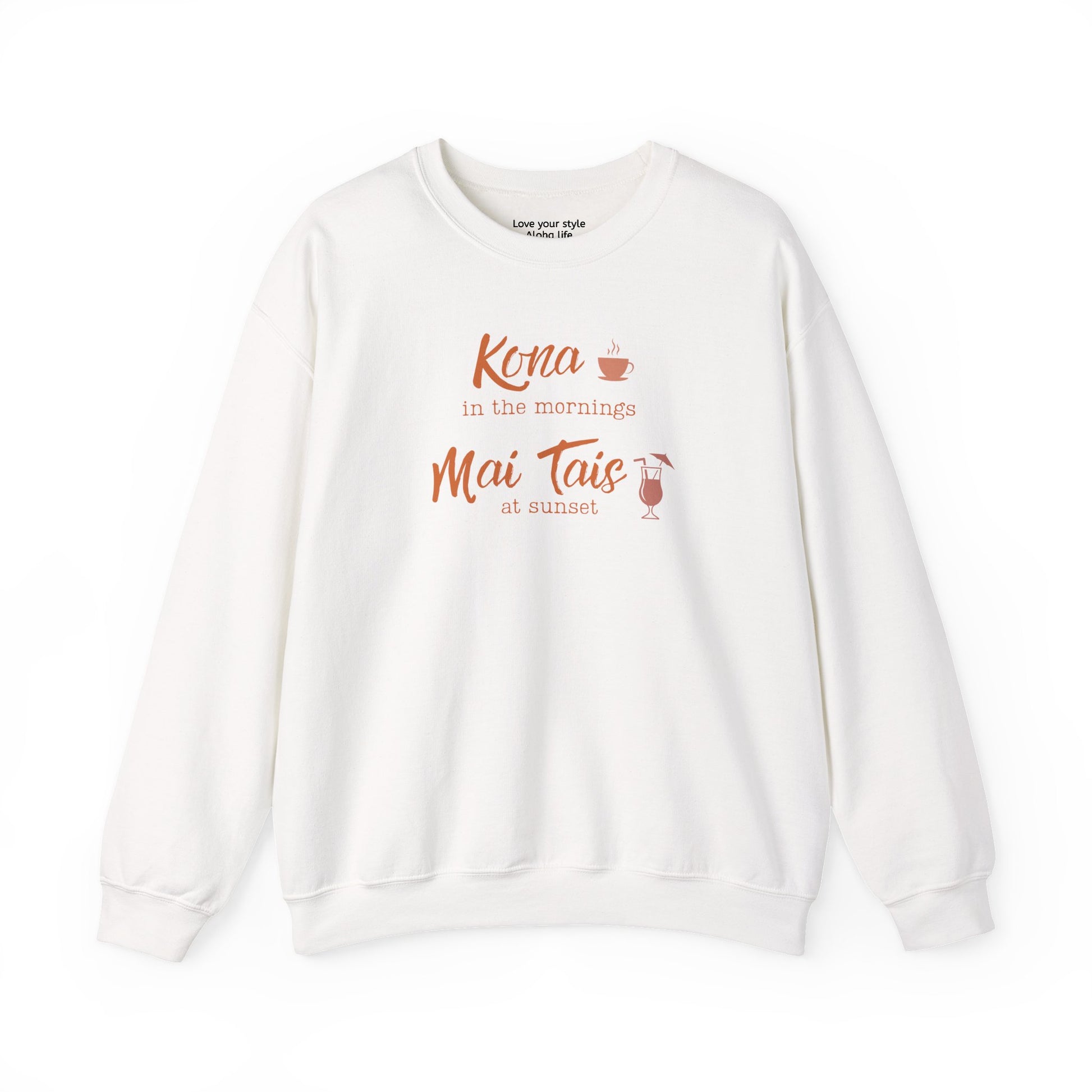 An white crewneck sweatshirt featuring a coral orange graphic print on the front that reads 'Kona in the mornings Mai Tais at sunset' with small illustrations of a coffee cup and a cocktail glass.
