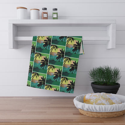 A kitchen towel with a tropical palm tree sunset pattern 'Kailua Hawaii' hangs from a white wall-mounted rack in a bright kitchen setting.