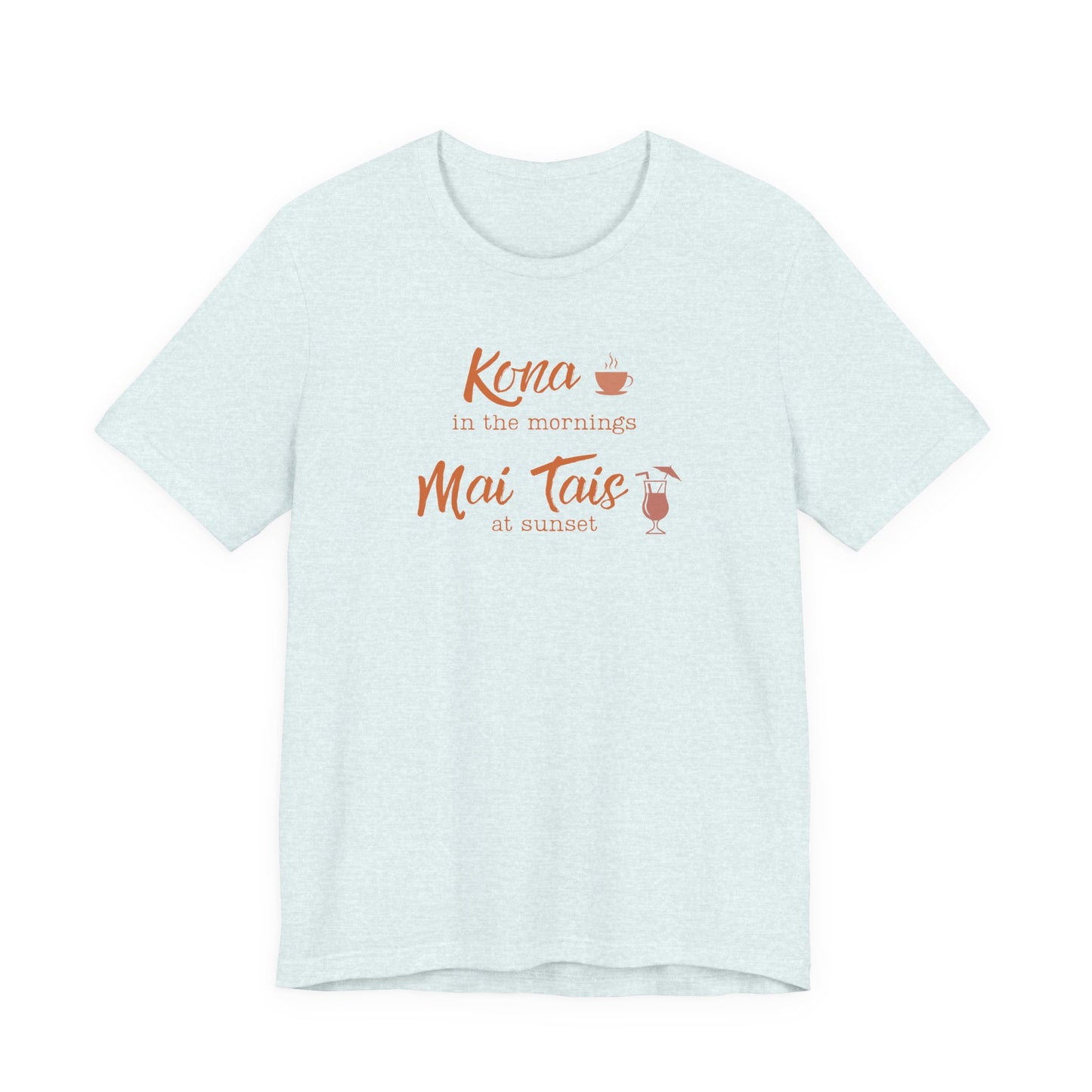 A light heather blue short-sleeve t-shirt with a graphic print on the front reading 'Kona in the mornings Mai Tais at sunset' in orange script, accompanied by small illustrations of a coffee cup and a cocktail glass.