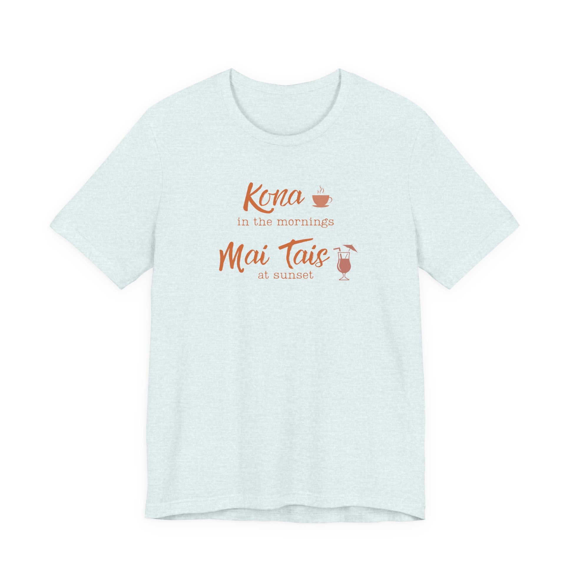 A light heather blue short-sleeve t-shirt with a graphic print on the front reading 'Kona in the mornings Mai Tais at sunset' in orange script, accompanied by small illustrations of a coffee cup and a cocktail glass.