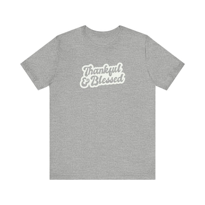 An athletic grey short-sleeve t-shirt with a white graphic text print reading 'Thankful & Blessed' on the chest, displayed against a solid white background.