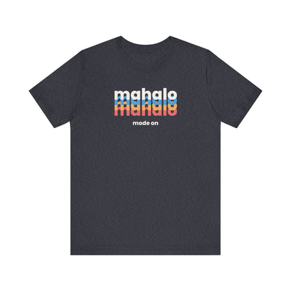 A  navy heather short-sleeve crewneck t-shirt with a retro-style chest graphic reading 'mahalo mode on' in white, blue, and orange lettering, displayed on a solid white background.