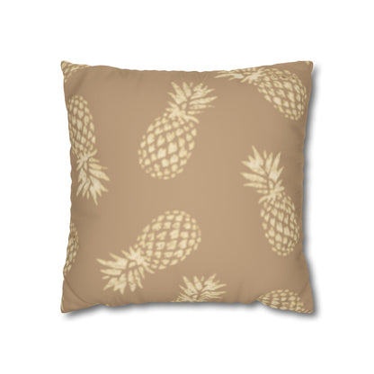 A square throw pillow featuring a repeating pineapple pattern in a light cream color on a warm tan background, shown against a plain white background.
