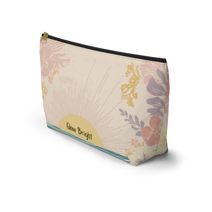 A rectangular zippered pouch with a vintage-inspired floral design on a cream background. The design features a gold sunburst, pink and purple flowers, and a teal stripe along the bottom edge.