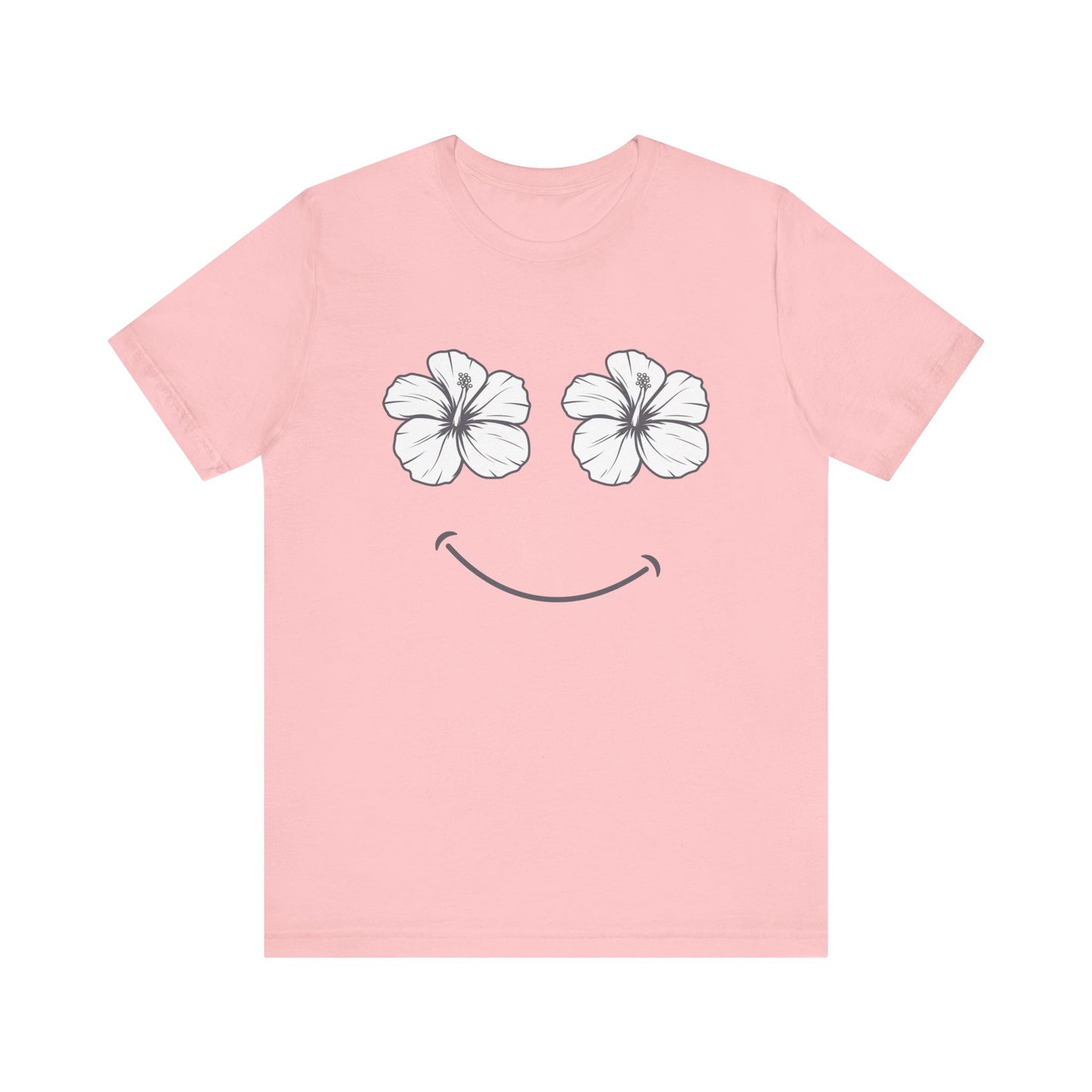 A light pink short-sleeve t-shirt with a graphic of two white hibiscus flowers forming eyes and a simple black smiley mouth on the front, displayed against a solid white background.