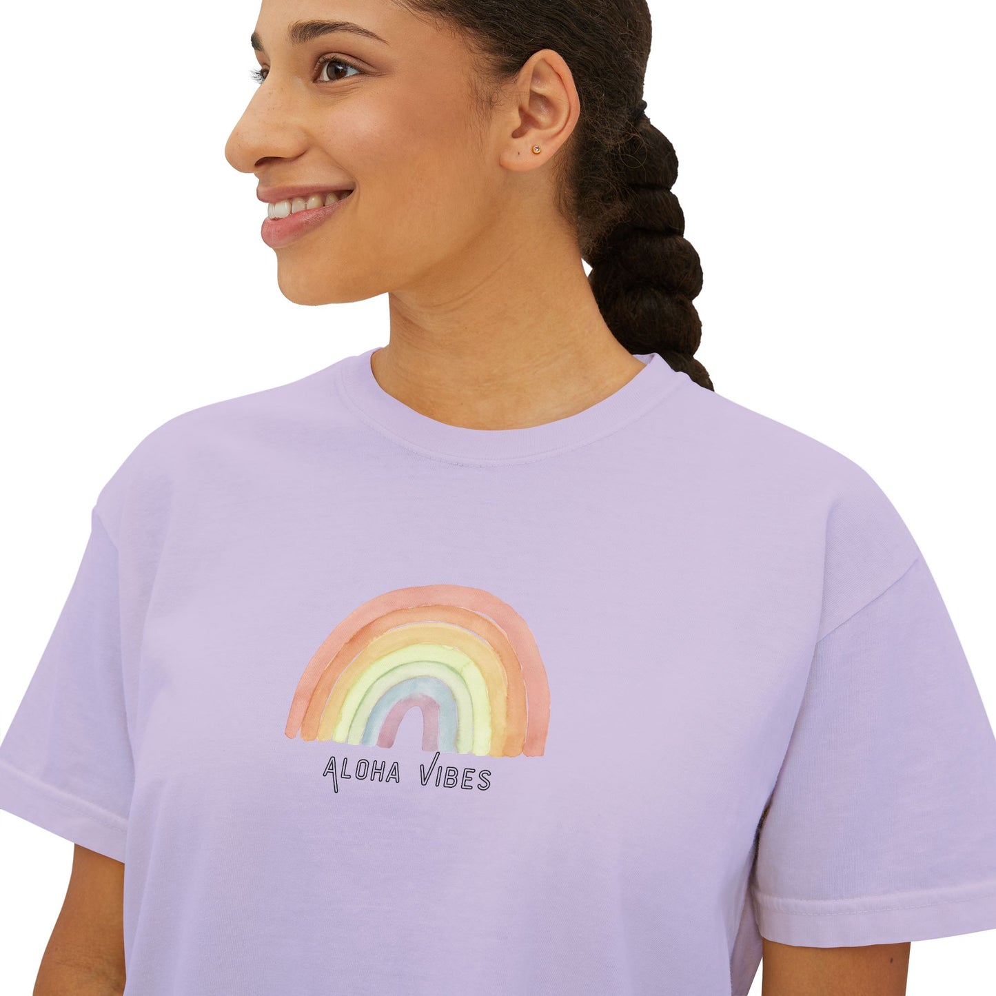 A woman wearing a light lavender crewneck t-shirt with a watercolor rainbow graphic and the text 'ALOHA VIBES' printed on the chest, shown against a plain white background.