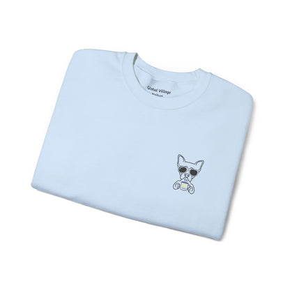 A light blue folded crewneck sweatshirt with a small graphic of a cartoon dog wearing sunglasses on the left chest, displayed on a clean white background.