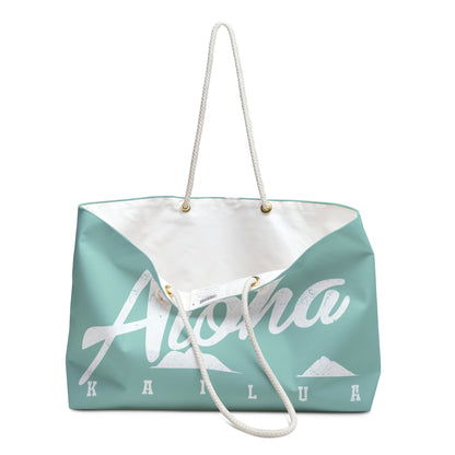 A mint green and white tote bag featuring the word 'Aloha' in white script with mountain graphics and the text 'KAILUA' underneath, complete with white rope handles.