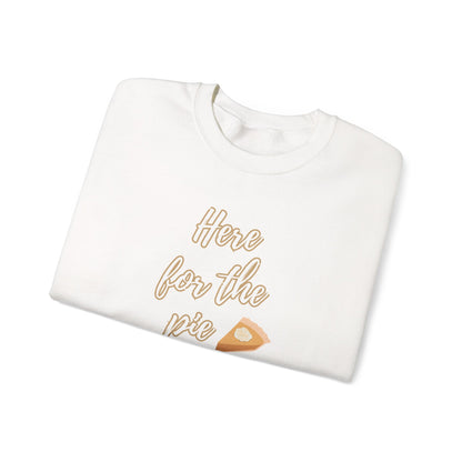 A folded white crewneck sweatshirt featuring a graphic print that reads 'Here for the pie' in a gold cursive font, accompanied by a small slice of pie illustration.