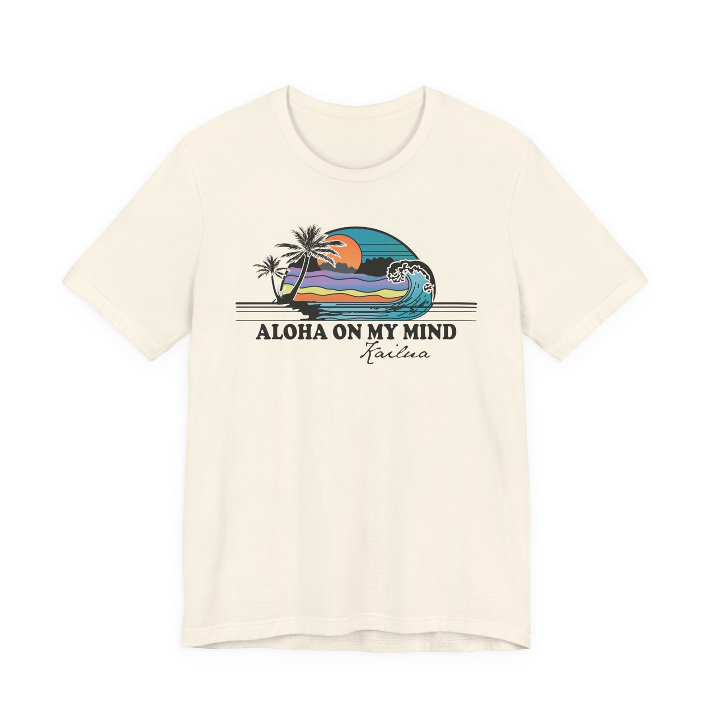An off-white short-sleeve t-shirt with a retro graphic of a Hawaiian wave and palm trees, featuring the text 'ALOHA ON MY MIND' and 'Kailua' underneath.