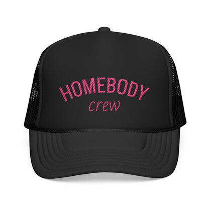 A black trucker-style cap with pink embroidered text reading 'HOMEBODY crew' on the front, shown against a plain white background.