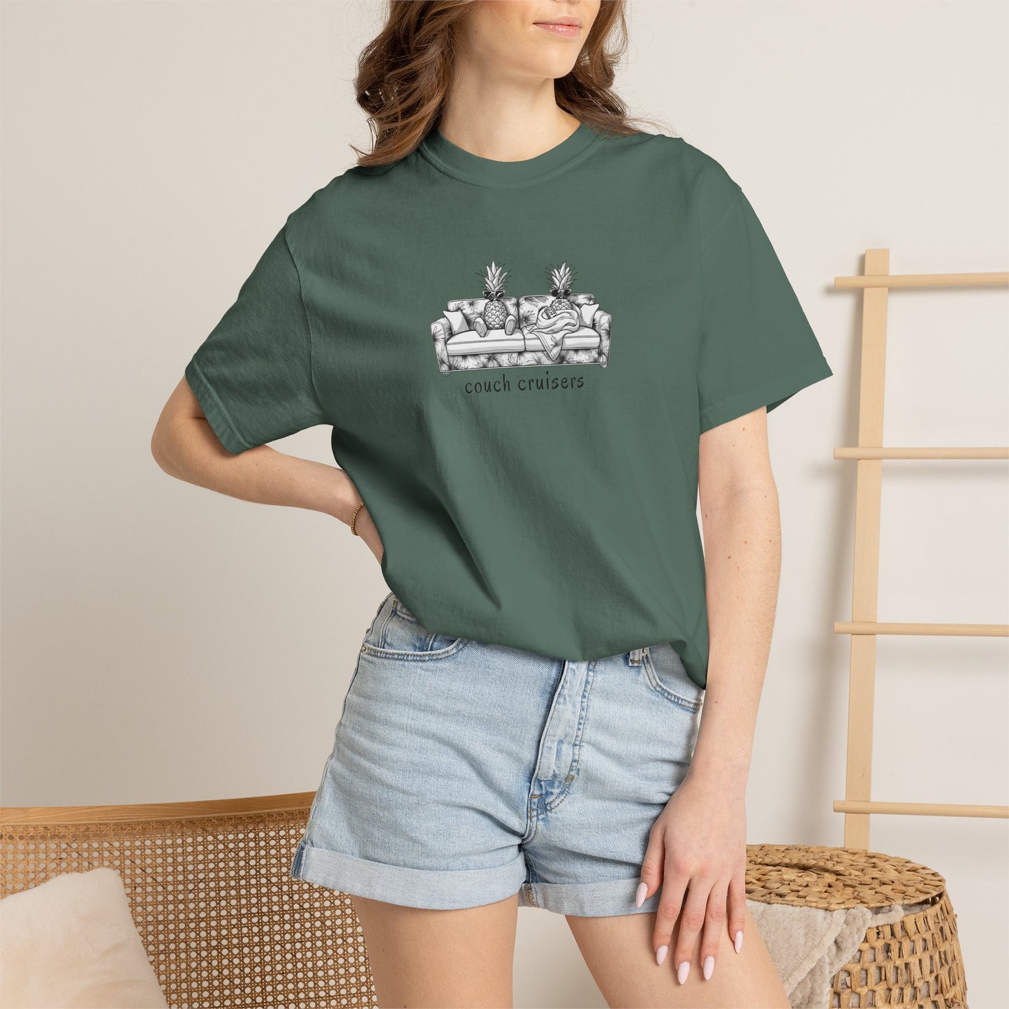 Woman wearing green Couch Cruisers Comfort Colors graphic tee with denim shorts
