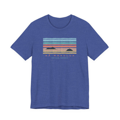 A heathered blue short-sleeve t-shirt with a retro sunset graphic on the chest featuring the text 'NA MOKULUA KAILUA, HAWAII'.