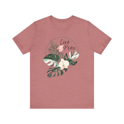 A heathered dusty rose short-sleeve t-shirt with a tropical graphic on the chest featuring green monstera and palm leaves, white flowers, and the words 'Live Pono' in a circle.