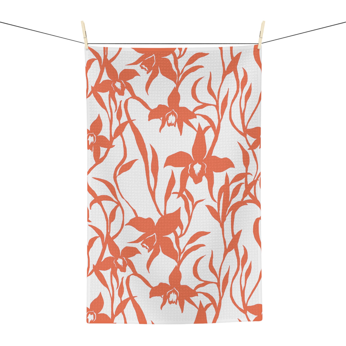 A rectangular white kitchen towel or tea towel featuring a bold coral orange floral pattern of orchids and leaves, shown flat against a solid white background.
