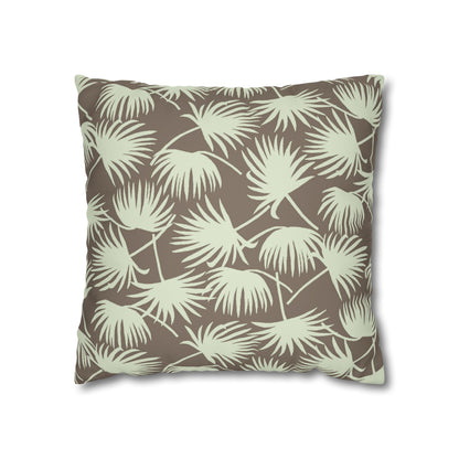A square throw pillow featuring a repeating palm leaf pattern in a light sage green on a warm taupe-brown background, shown against a plain white studio background.