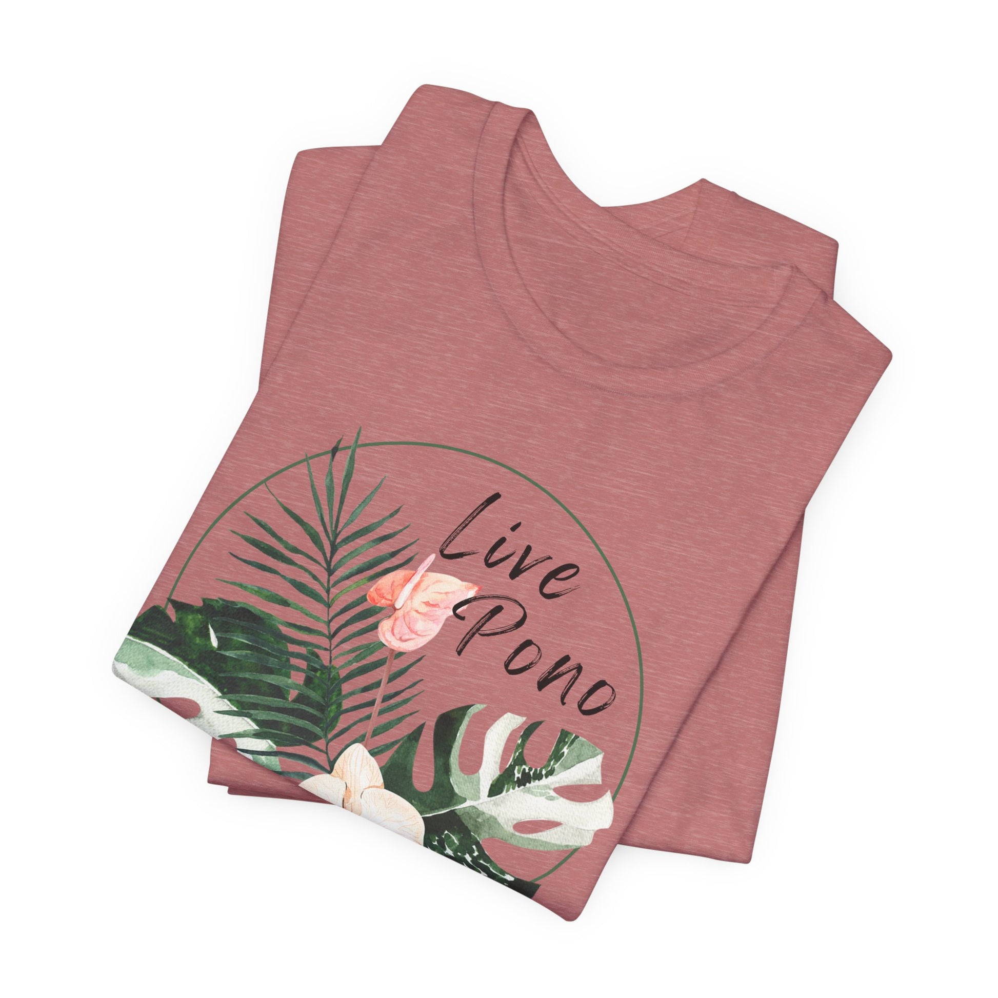 A folded heathered dusty rose t-shirt featuring a tropical graphic with green palm and monstera leaves, a pink flower, and the words 'Live Pono' in black script, displayed on a clean white background.