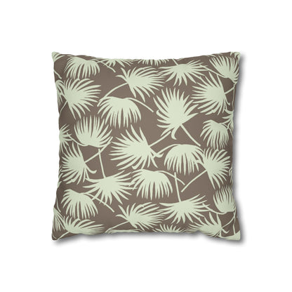 A square throw pillow featuring an all-over palm frond pattern in sage green on a warm taupe-brown background, shown against a plain white studio background.