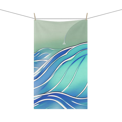 A tea towel featuring an abstract ocean wave design in shades of teal, blue, and white, suspended by two wooden clothespins on a thin horizontal line against a plain white background.