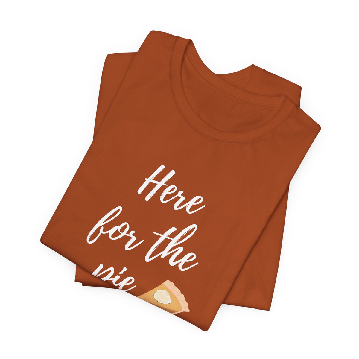 A folded rust t-shirt with white script text reading 'Here for the pie' and a small slice of pie graphic near the bottom, displayed on a clean white background.