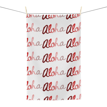 Red Aloha Hawaiʻi kitchen towel with repeating script design in shades of red on white