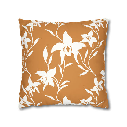 A square throw pillow featuring a white floral and leaf pattern on a warm terracotta orange background, shown against a plain white studio backdrop.
