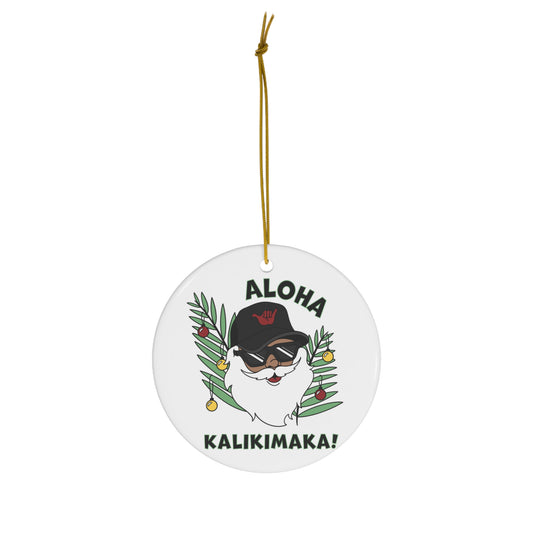 White ceramic ornament featuring Santa in sunglasses and black shaka hat with tropical greenery and Aloha Kalikimaka lettering.