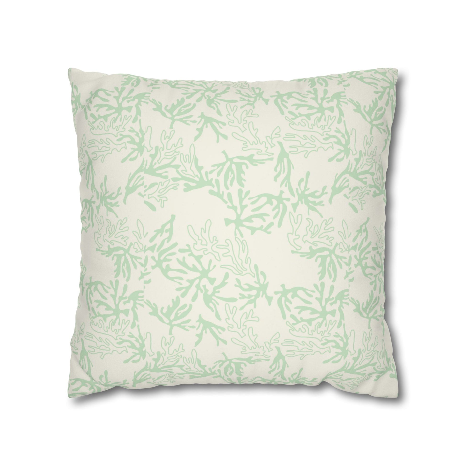 A square throw pillow featuring a light sage green coral pattern on an off-white background, shown against a plain white studio backdrop.