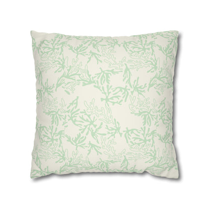 A square throw pillow featuring a light sage green coral pattern on an off-white background, shown against a plain white studio backdrop.
