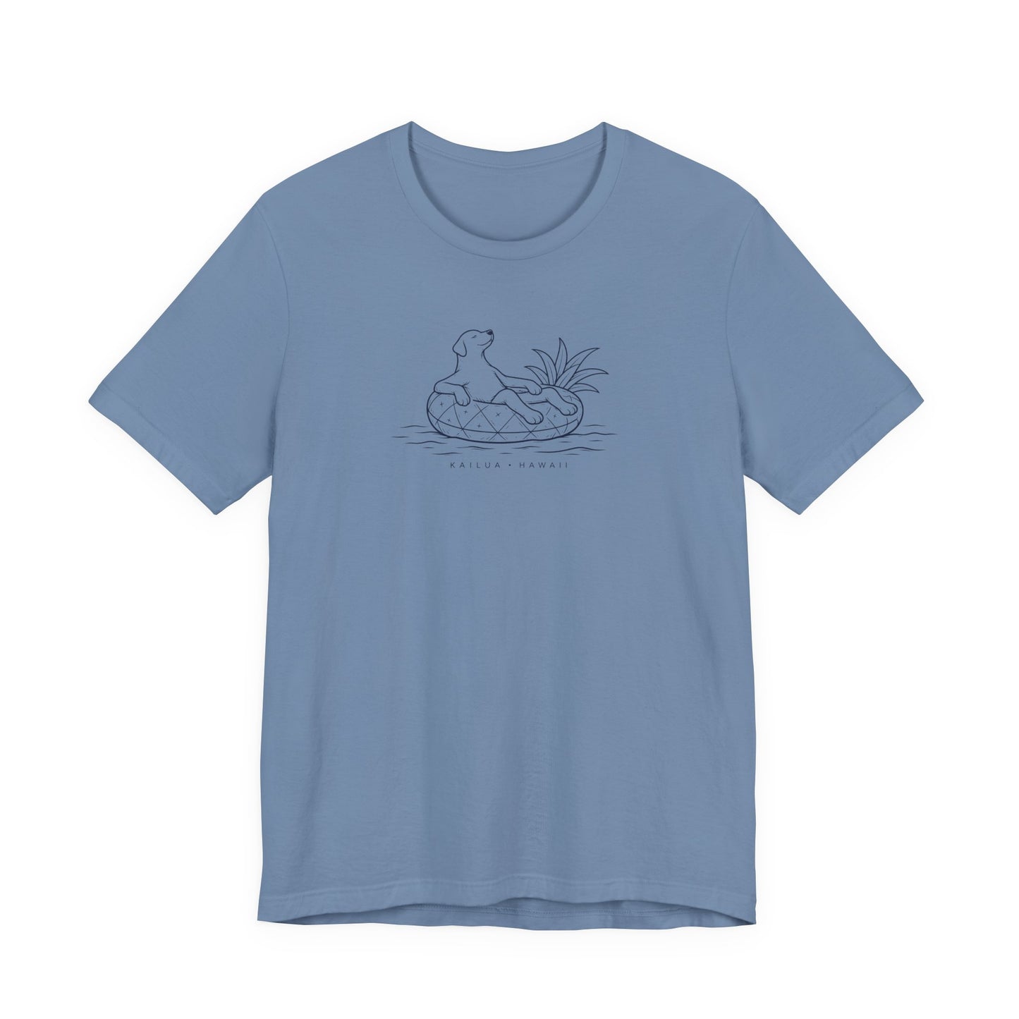 A light blue short-sleeve crewneck t-shirt featuring a dark blue line art graphic of a dog in a pineapple floatie, with the text 'KAILUA - HAWAII' printed below.