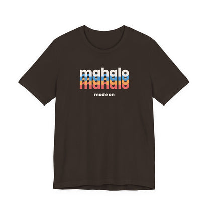 A brown short-sleeve crewneck t-shirt with a retro-style chest graphic reading 'mahalo mode on' in white, blue, and orange lettering, displayed on a solid white background.