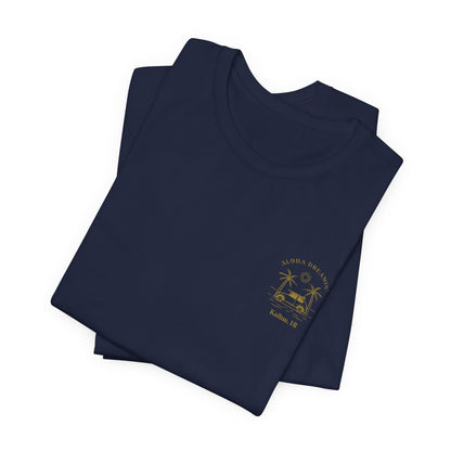 A folded navy short-sleeve t-shirt shown from the front, featuring a gold-colored retro graphic of a classic car between two palm trees with the text 'ALOHA DREAMIN'' and 'Kailua, HI' on the left chest.