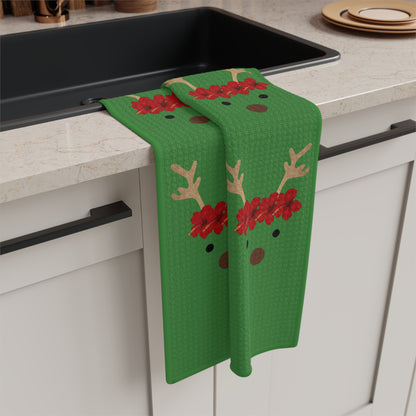 Green Reindeer and Rudolph holiday kitchen towel with red nose design hanging off a kitchen sink