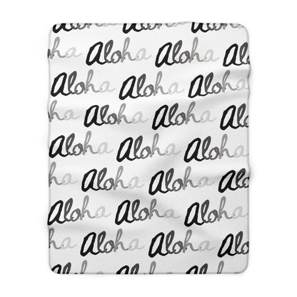 Aloha grayscale sherpa fleece blanket with a repeating black, white and gray island-inspired design.