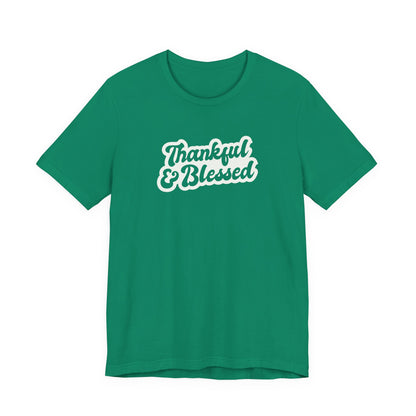 A green short-sleeve t-shirt with a white graphic text print reading 'Thankful & Blessed' on the chest, displayed against a solid white background.