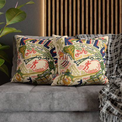 Two decorative throw pillows with a colorful vintage-style map illustration pattern of Kailua Oahu, styled on a gray sofa next to a black-and-white plaid throw blanket.