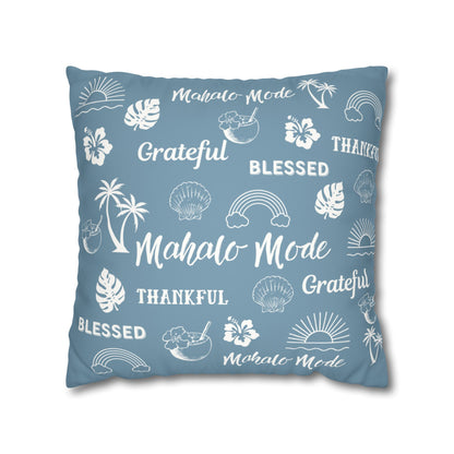 A square throw pillow in dusty blue with a white tropical-themed print featuring the words 'Mahalo Mode', 'Grateful', 'Blessed', and 'Thankful' along with palm trees, hibiscus flowers, and rainbows, shown on a plain white background.
