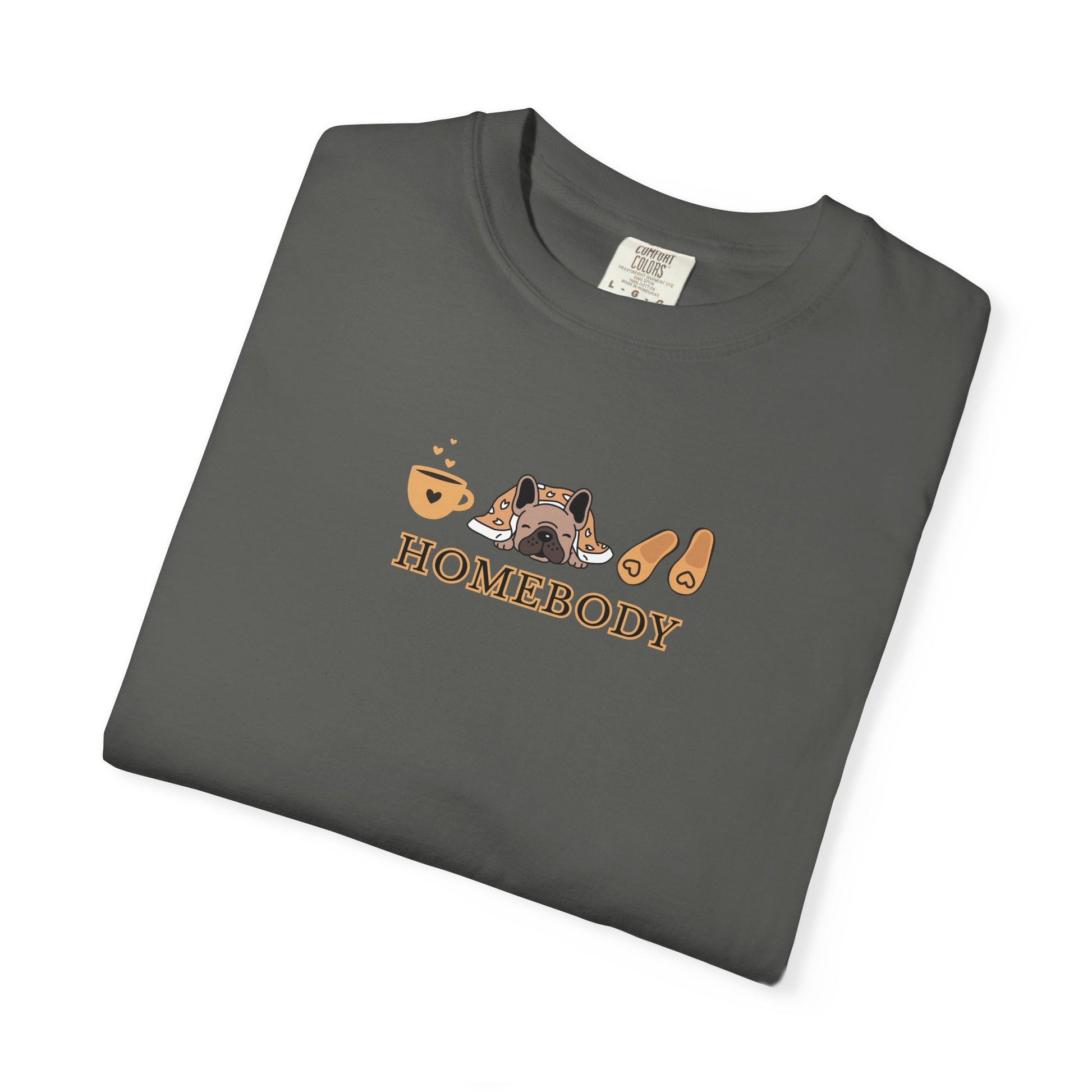 A folded dark gray short-sleeve crewneck t-shirt with a graphic on the chest depicting a dog under a blanket, a coffee mug, a pair of house slippers, and the word 'HOMEBODY' in brown text.