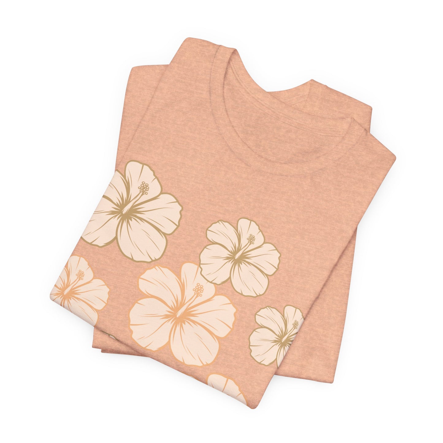 Folded peach Hibiscus All Over Graphic Tee featuring scattered tropical hibiscus flowers on a soft unisex tee inspired by island life in Hawaii.