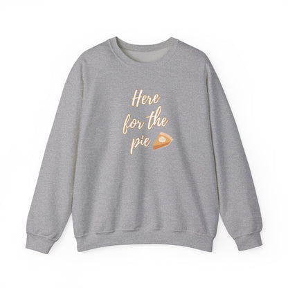 A heather gray crewneck sweatshirt featuring the phrase 'Here for the pie' in a light beige script font, accompanied by a small slice of pumpkin pie graphic on the front.