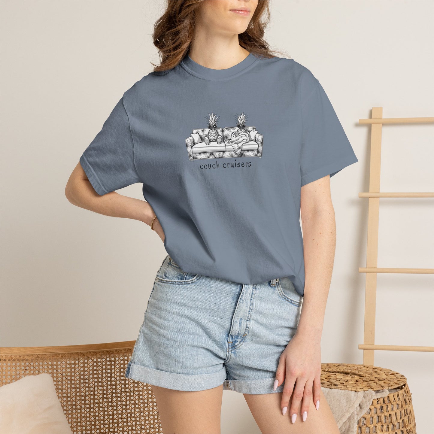 Woman wearing blue Couch Cruisers Comfort Colors graphic tee with denim shorts
